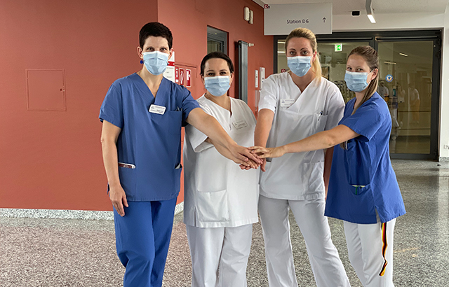Pflegekräfte legen ihre Hände zusammen